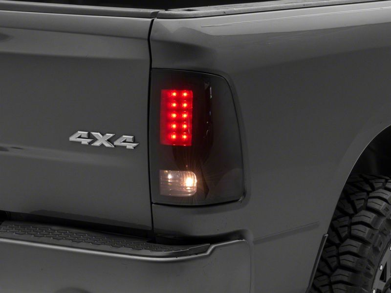 Load image into Gallery viewer, Raxiom 09-18 Dodge RAM 1500/2500/3500 Axial Series LED Tail Lights- BlkHousing- SmokedLens
